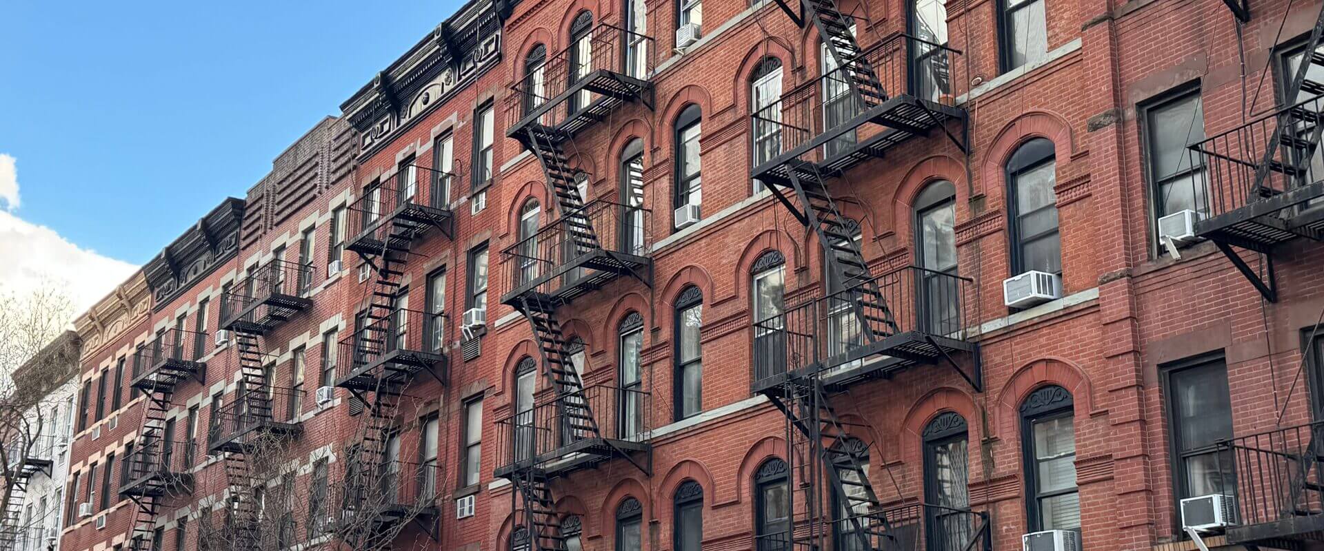 Classic red brick brownstones with iron fire escapes on the Upper East Side